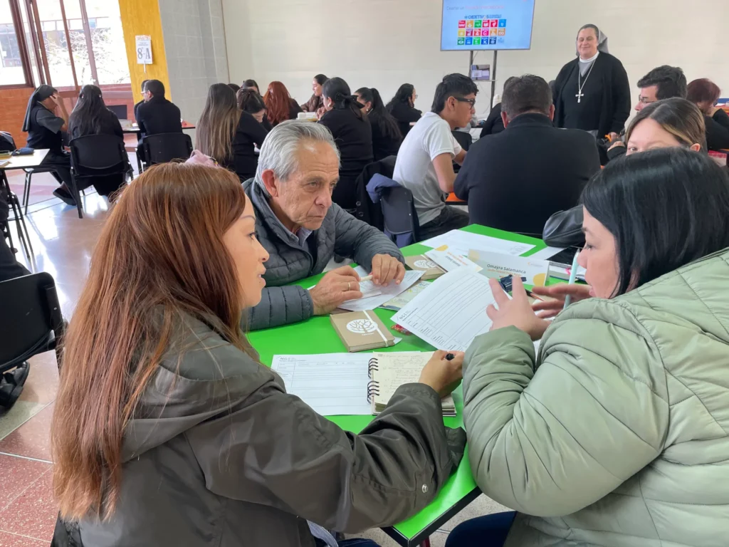 Docentes trabajando en grupos durante la formación sobre Proyectos Interdisciplinares en Bogotá.